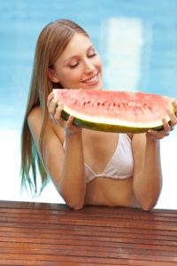 Frau mit Melone im Pool